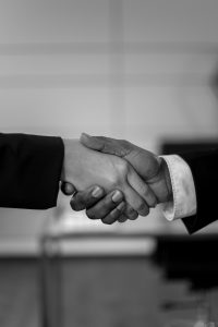 Close-up of a professional handshake in black and white, symbolizing agreement and partnership.